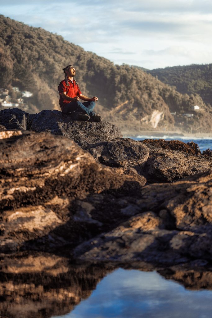 Persona sentada en las rocas contemplando en mar en Maicolpue sur de Chile
